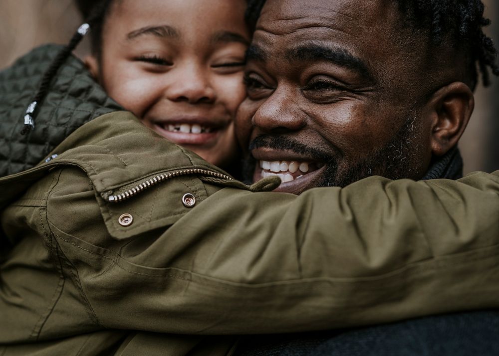Daughter hugging her dad, African-American family photo
