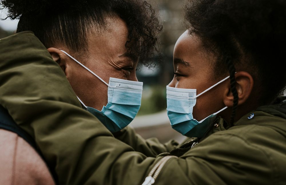 Mother and child putting on mask, COVID-19 photo