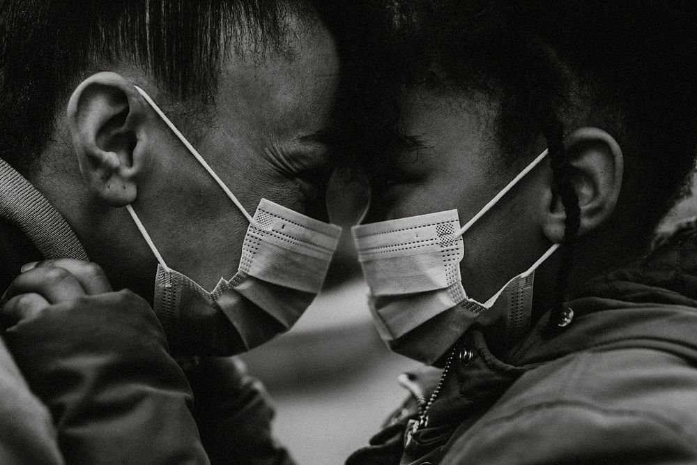 Mother and child putting on mask, black & white photo