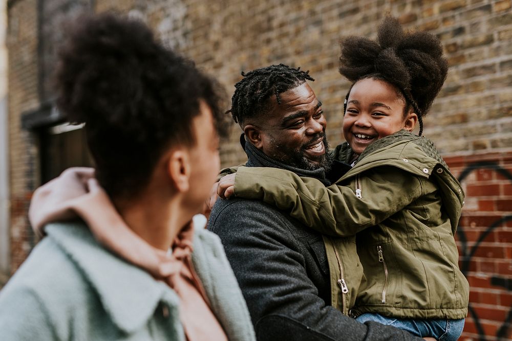 Happy black family laughing, walking in city