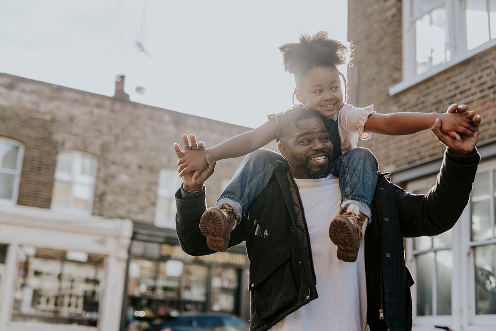 Happy dad carrying daughter on shoulders