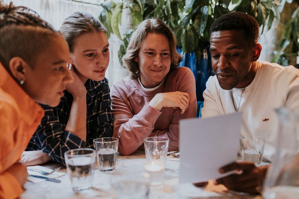 Diverse friends checking out menu at a restaurant