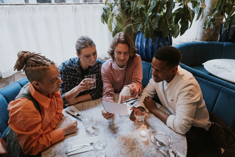 Diverse friends checking out menu at a restaurant