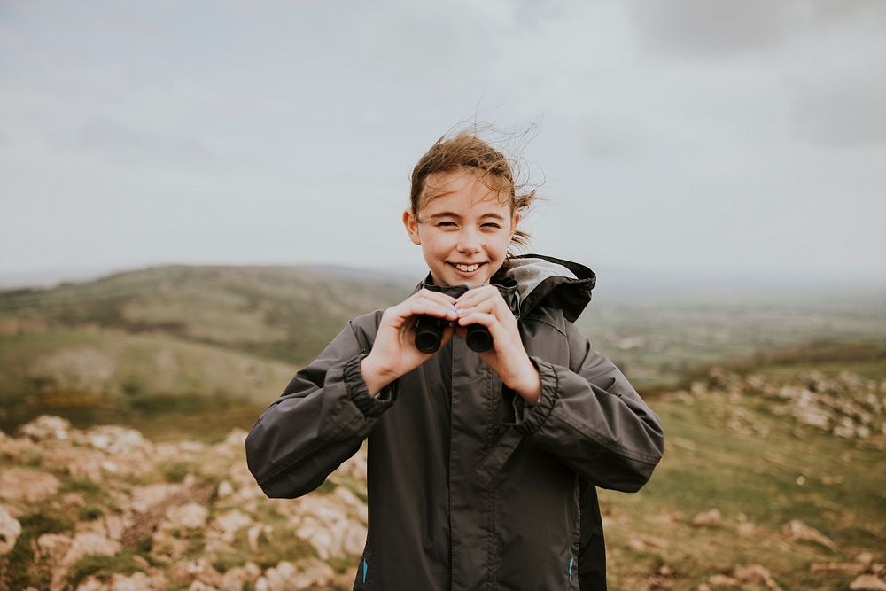 Girl using binoculars while hiking