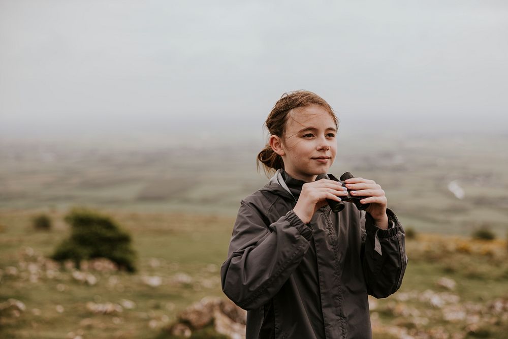 Girl using binoculars while hiking