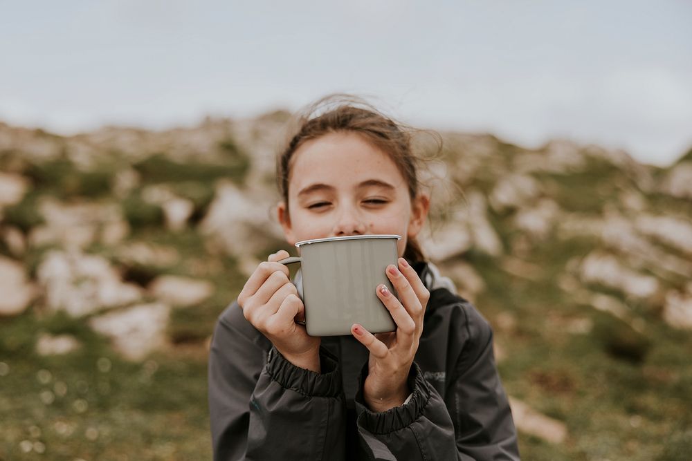 Girl drinking from mug, outdoor photo