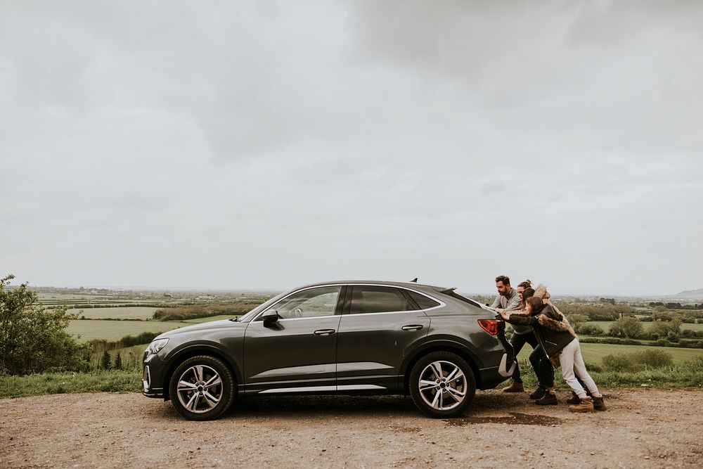 Family pushing broken car photo