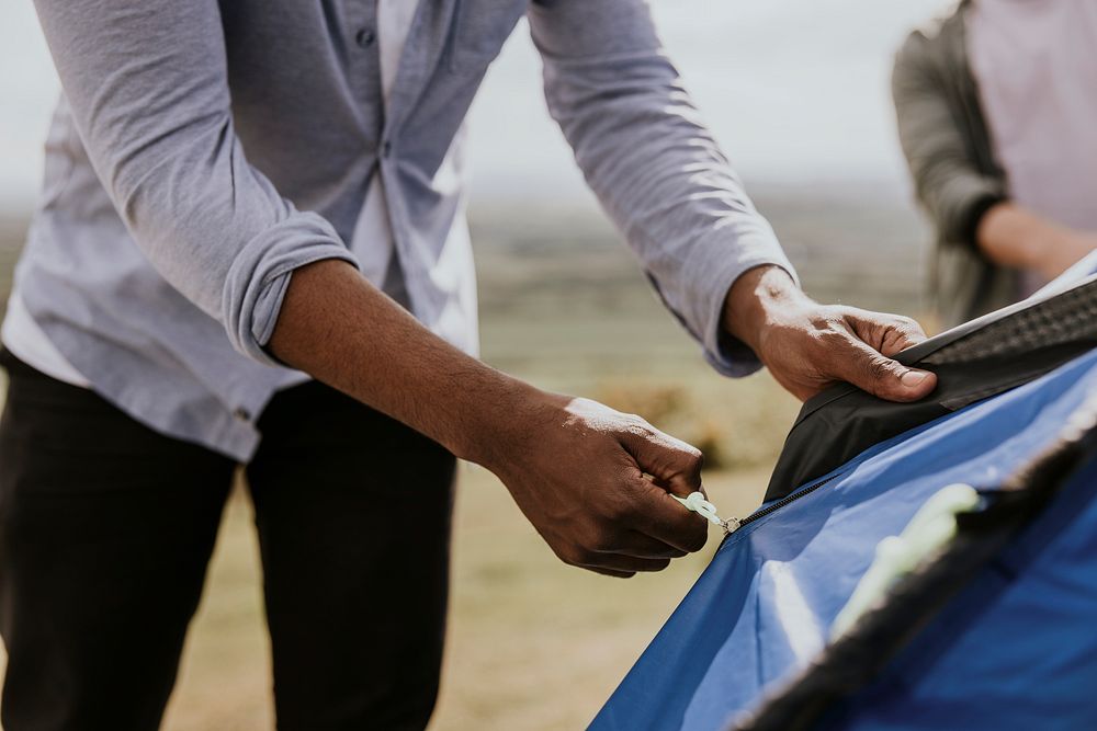 Man hand setting up camping tent, outdoor activity photo