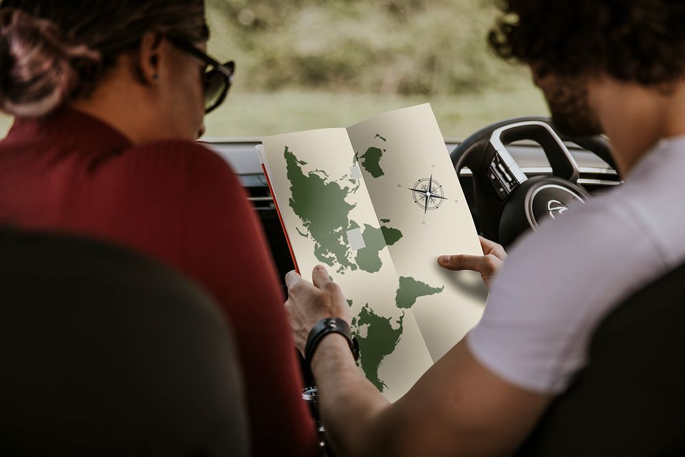 Couple reading map in car, road trip