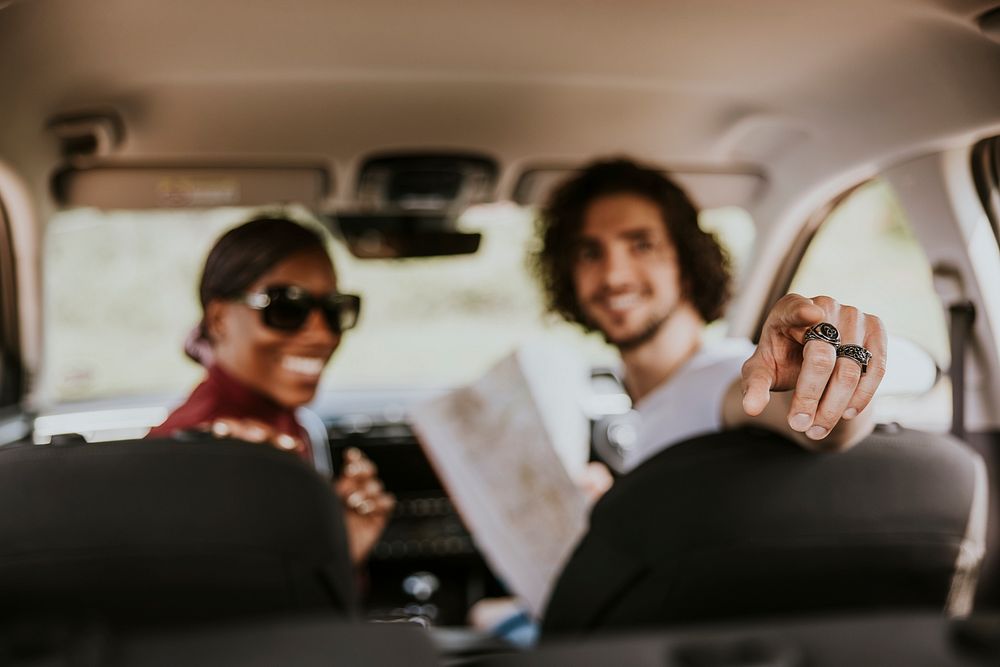 Road trip, man pointing at the back of car photo