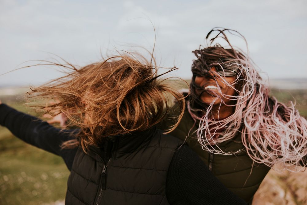 Smiling women with windy hair, outdoor activity