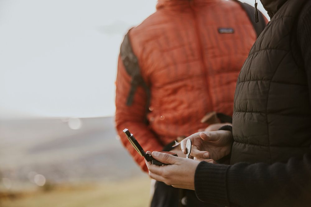 Hiker holding compass on hill photo