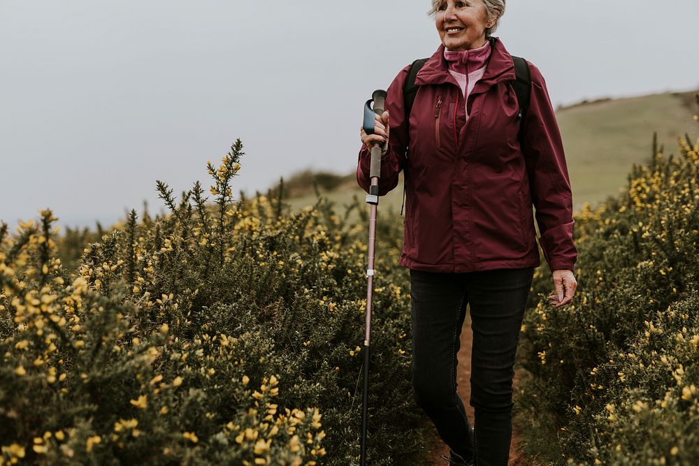 Senior woman hiking through flower field