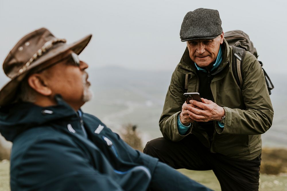 Man calling medic, injured friend while trekking