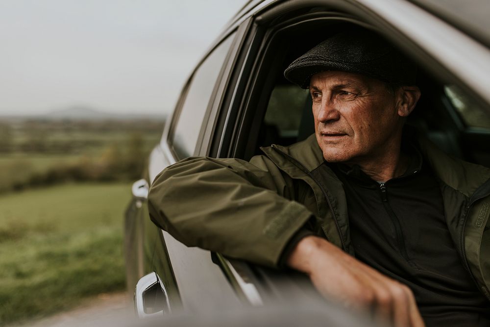 Senior man looking out car window