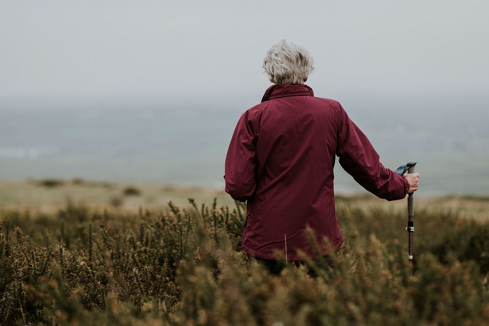 Senior woman trekking through field