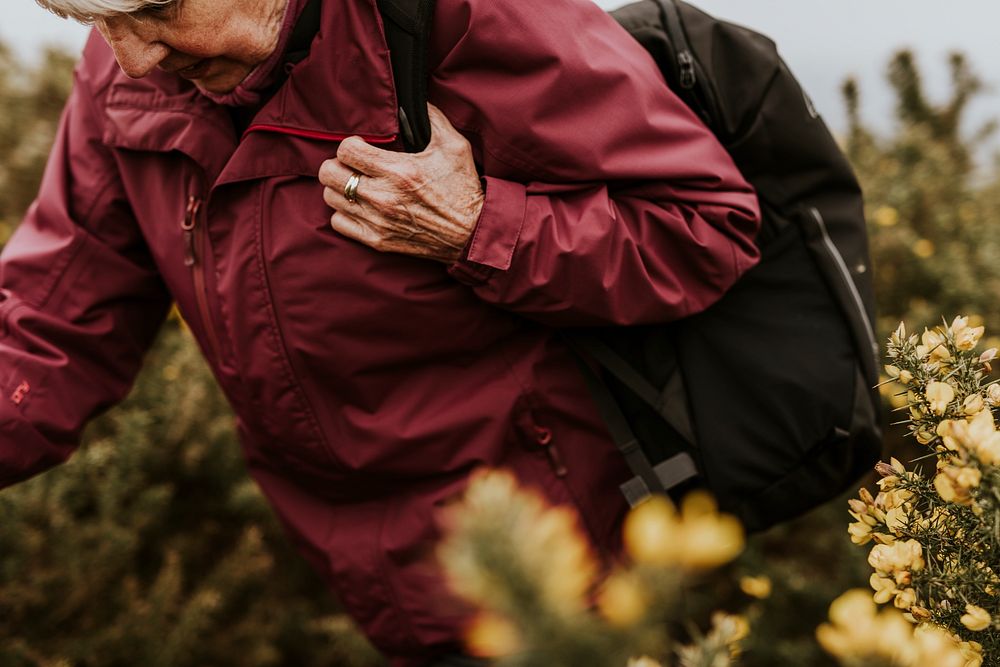 Senior woman hiking through flower field