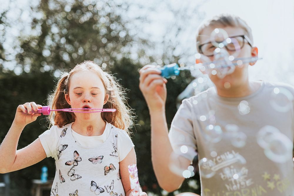 Brother & sister blowing bubbles, sibling love