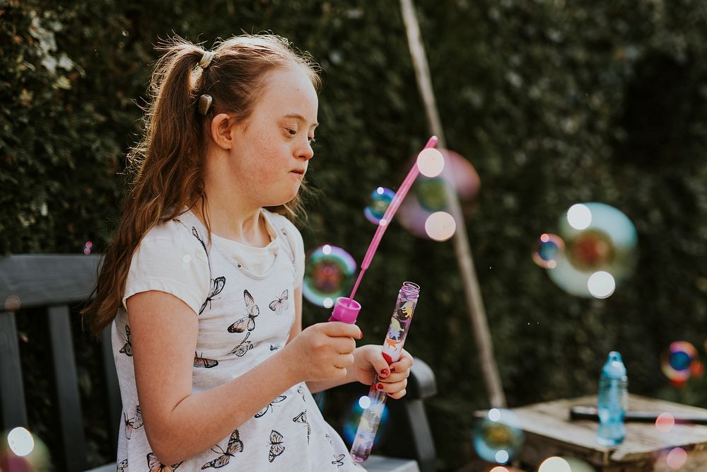 Girl with Down Syndrome blowing bubbles