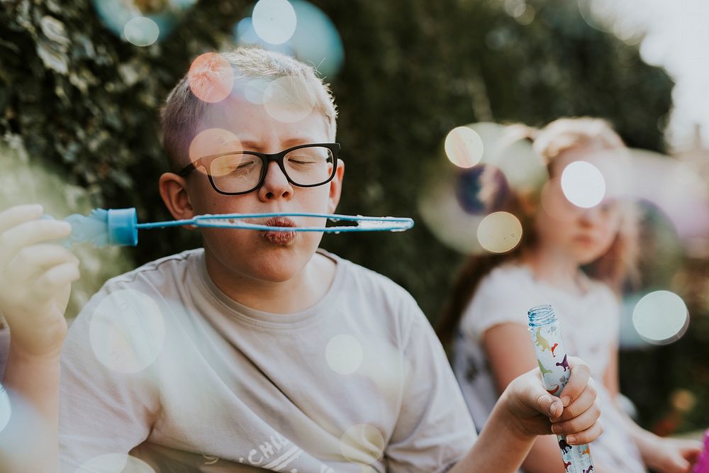 Boy blowing bubble, school holiday photo