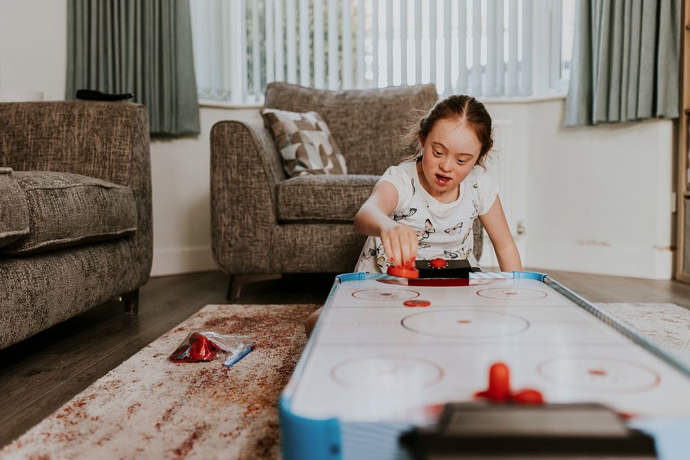 Girl with Down Syndrome playing air hockey