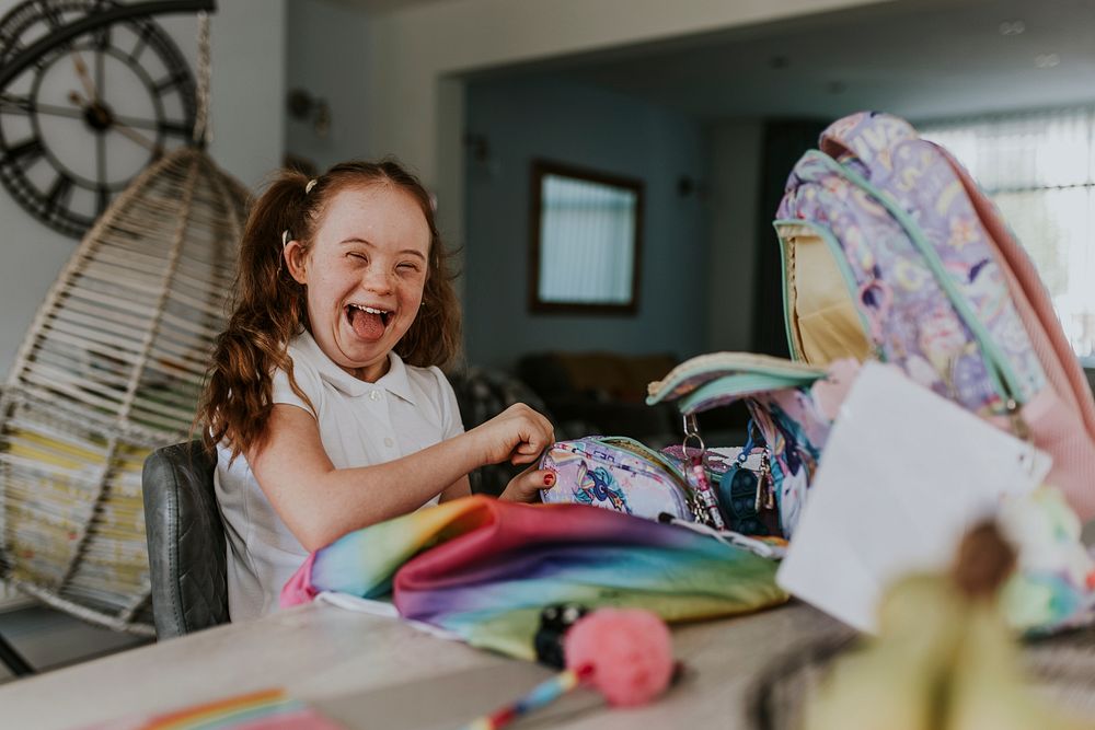 Happy girl with Down Syndrome, student getting ready for school