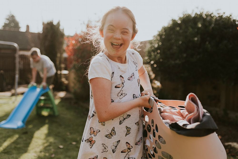 Girl with Down Syndrome doing laundry, house chore