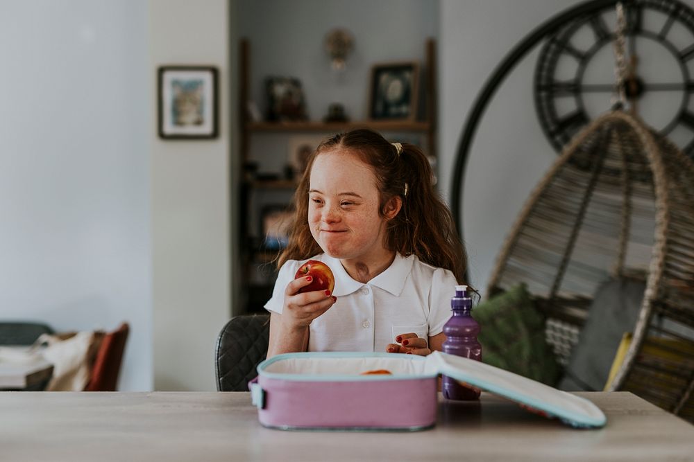 Happy girl holding apple, school lunch