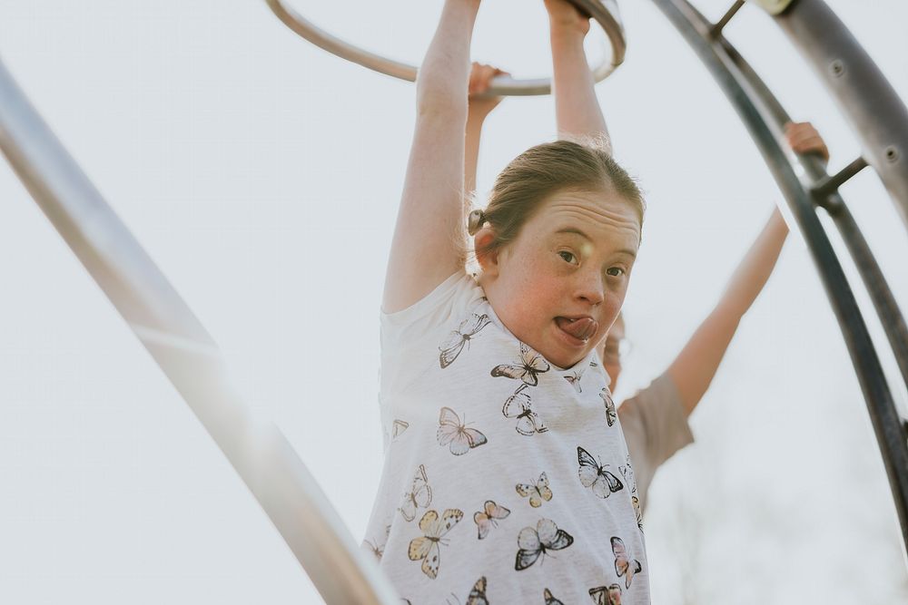 Little girl playing at playground, down syndrome awareness photo
