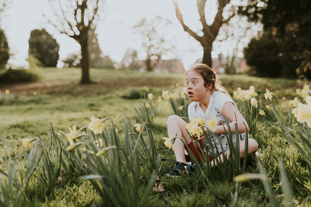 Little girl sitting in flower field