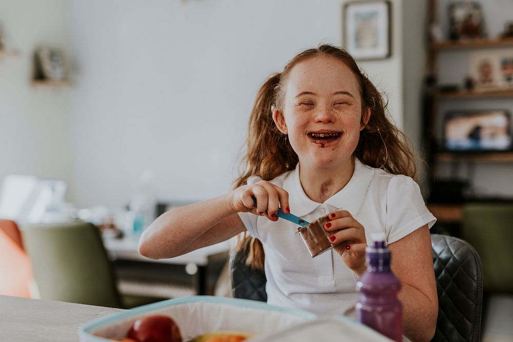 Girl with Down Syndrome eating chocolate pudding