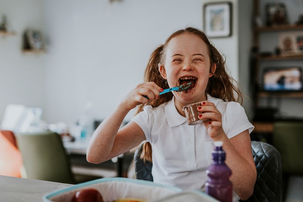 Girl with Down Syndrome eating chocolate pudding