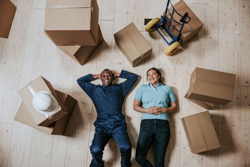 Happy moving service staff lying on the floor