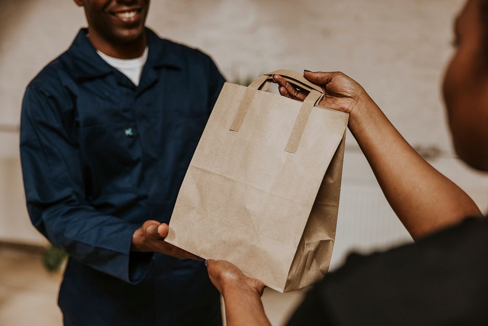Food delivery man handing bag to customer