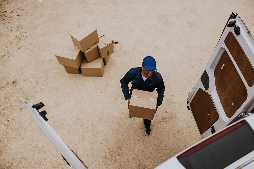 Removal service worker unloading box from the van