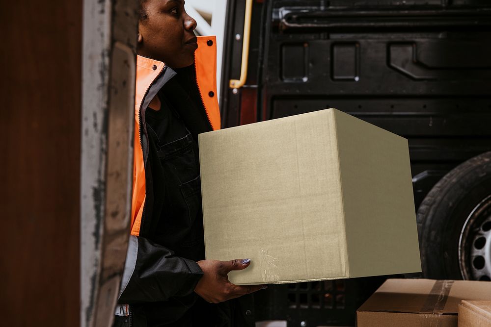 Woman loading boxes into truck, moving service