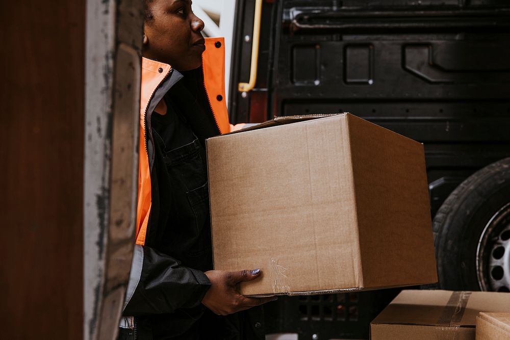 Worker carrying cardboard box, removal service