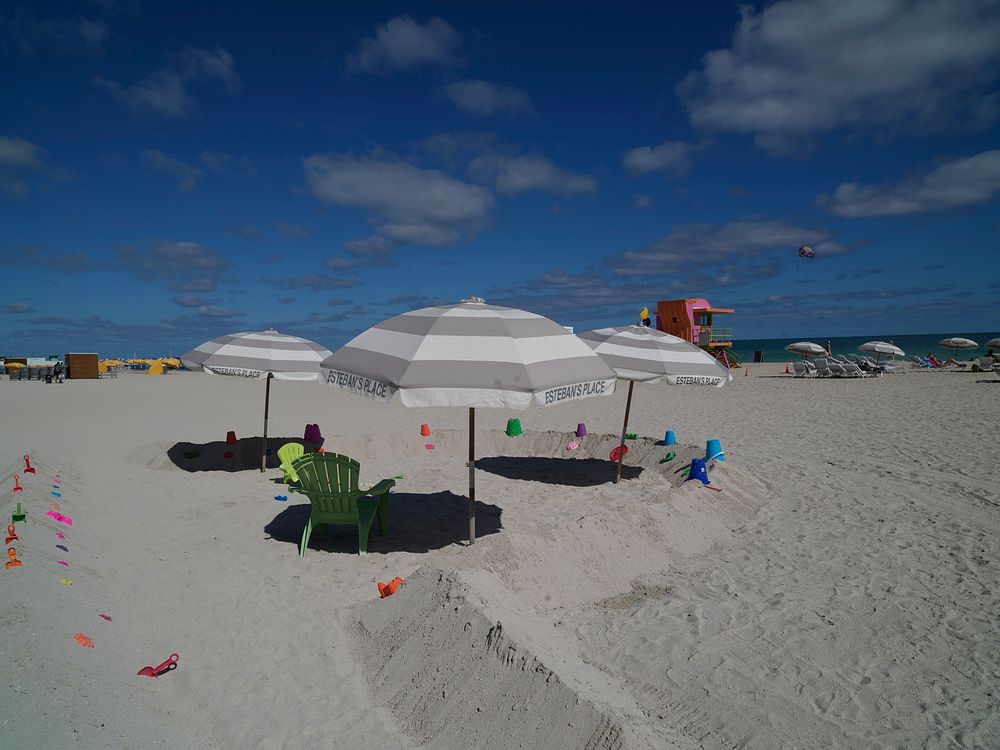                         Umbrellas, beach chairs, and a lifeguard station on the sand in the trendy South Beach section of…