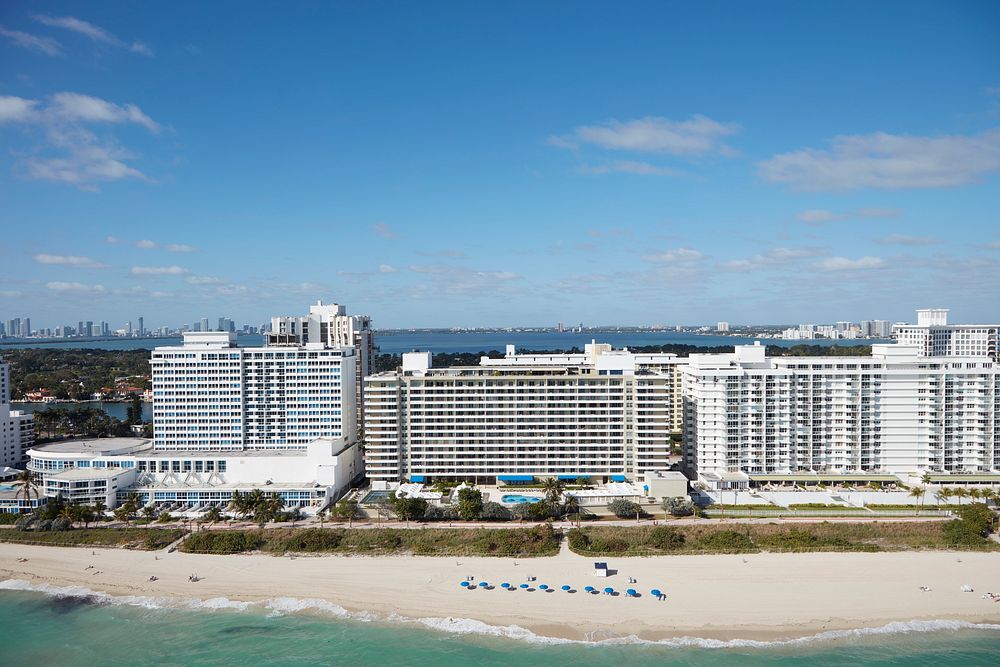                         Aerial view of a lavish seaside condominum apartment building in Miami Beach, a bony-finger-like…
