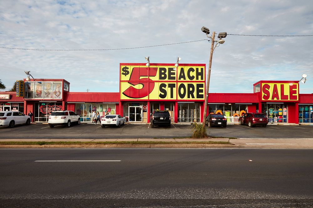                         There's no way to miss this and adjacent signs at a beachwear shop along the commercial strip in…