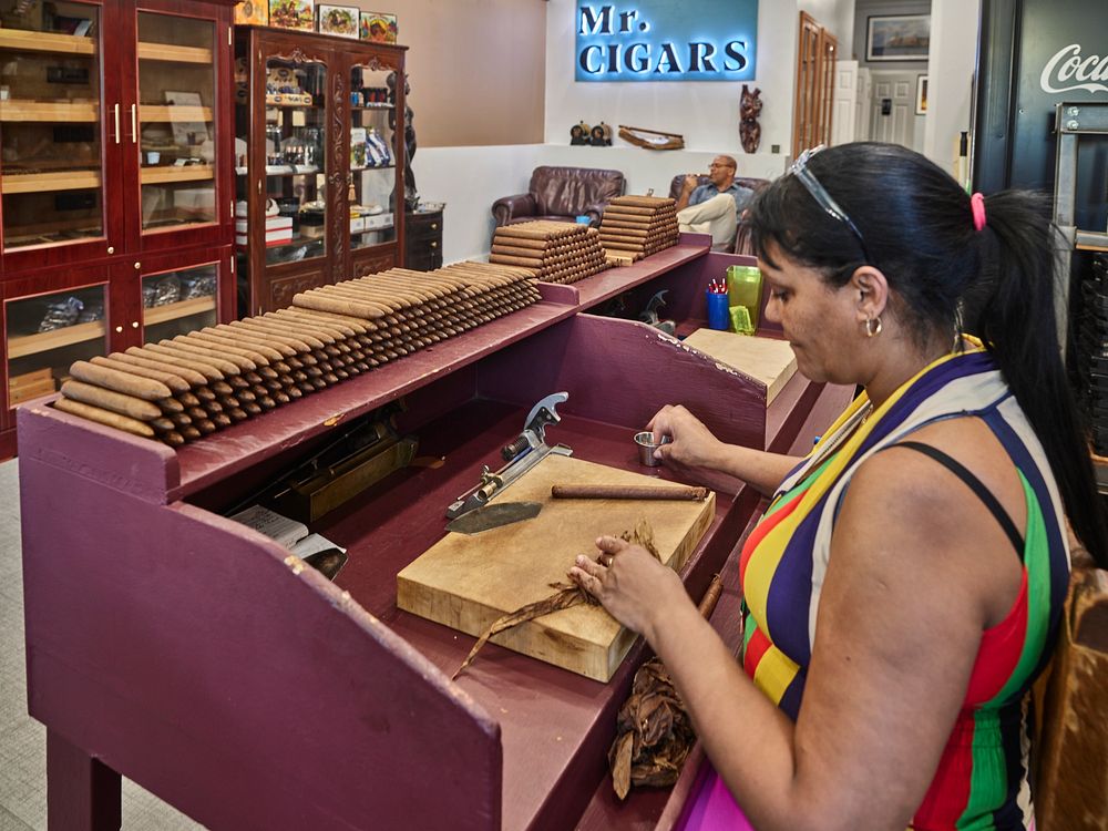                         Magalys Garrido rolls handmade cigars, one of which shop owner Fernando Morales lights and enjoys in…