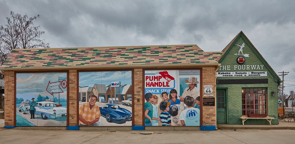                         Murals shift attention from the adjoining, classic, c.-1932 cottage-style Phillips-66 station, now…