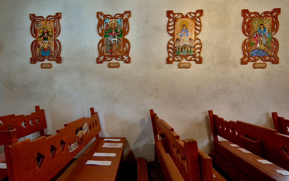                         Carved wooden pews in the sanctuary of at Santo Niño de Atocha Chapel, built in 1857 in Chimayo, a…