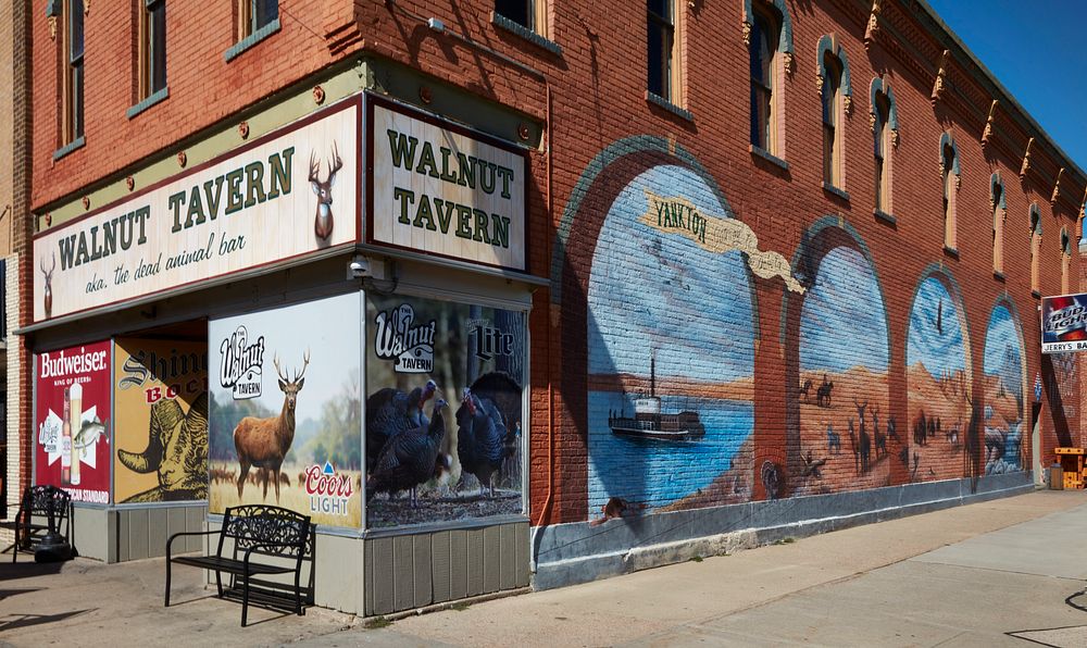                         A downtown corner that includes a mural depicting scenes on the Missouri River in Yankton, a small…