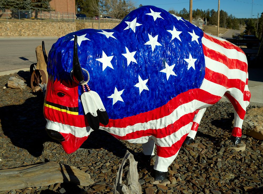                         A colorfully decorated buffalo, or American bison, sculpture on the street in Custer, South Dakota  …
