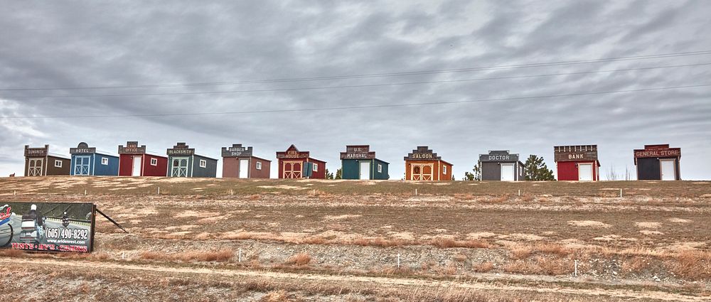                         These cabins on a hill, evoking an Old West town, attract potential customers to real cabins near…