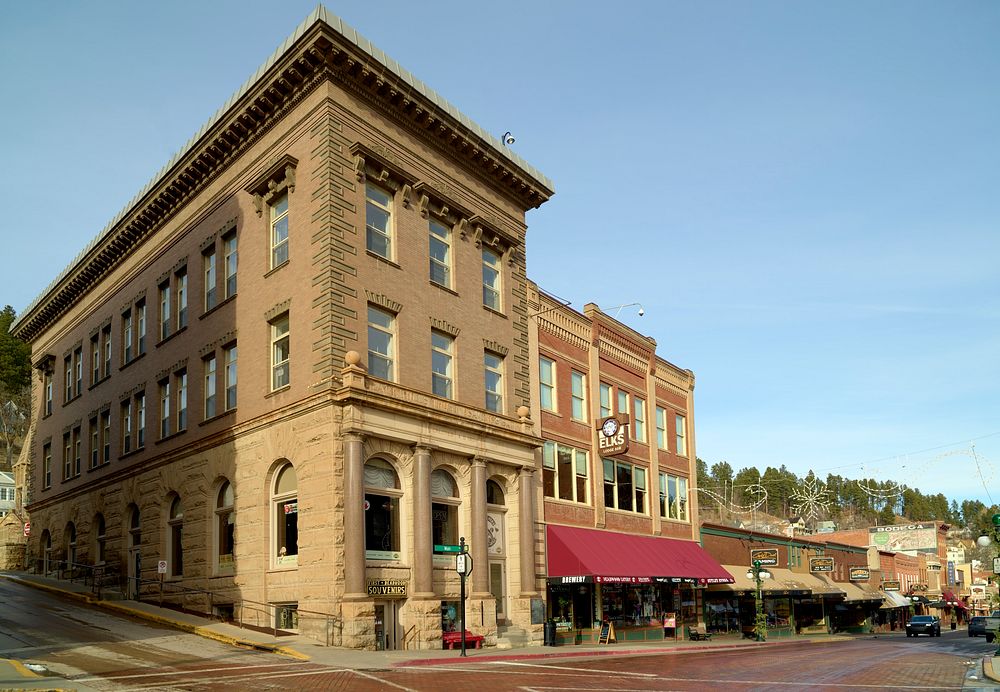                         An old savings-bank building and the adjacent, current (as of 2021) Elks Club lodge in Deadwood, a…