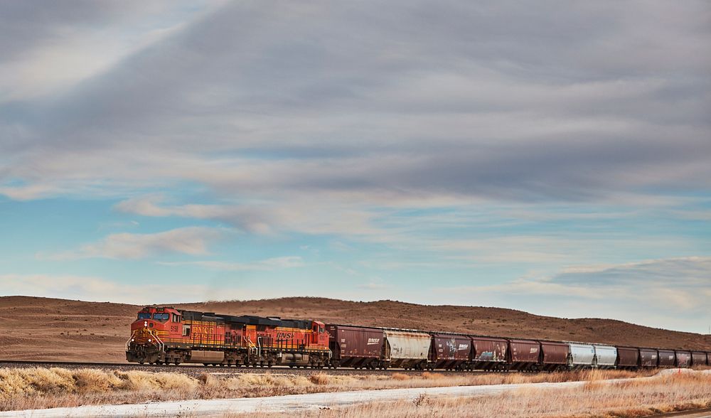                         A long freight train churns across the empty terrain of Grant County, Nebraska                      …