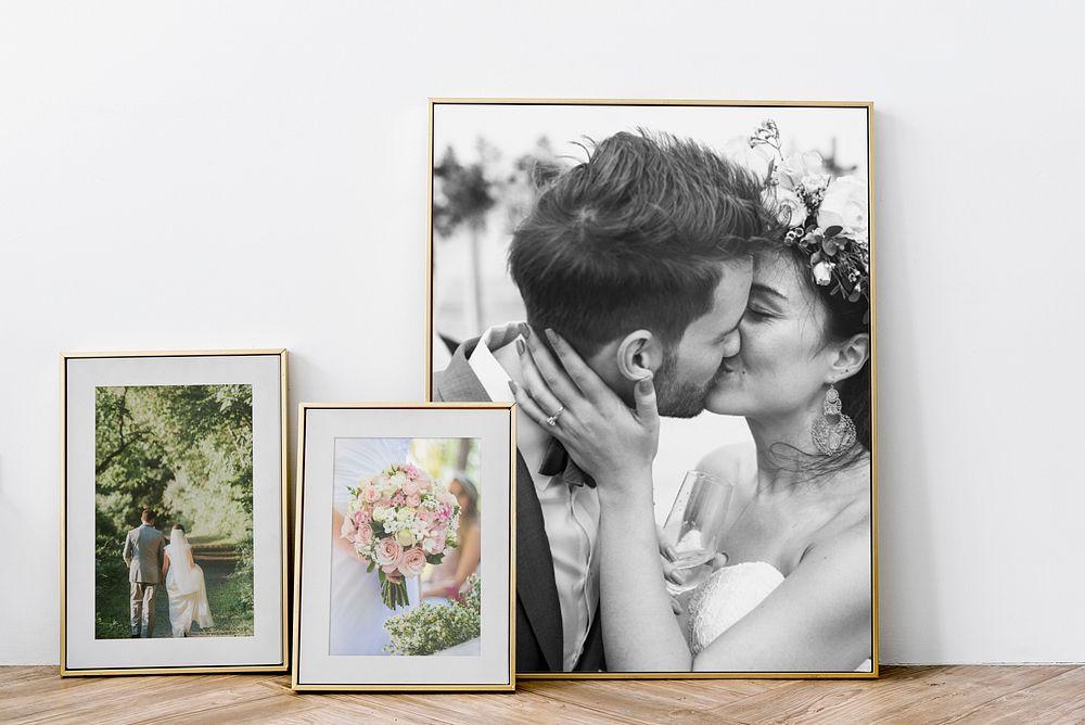Framed wedding photos leaning against a wall