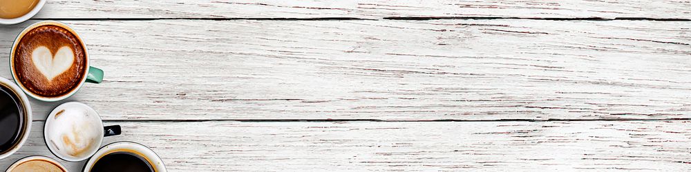 Coffee cups on a white rustic wooden textured background